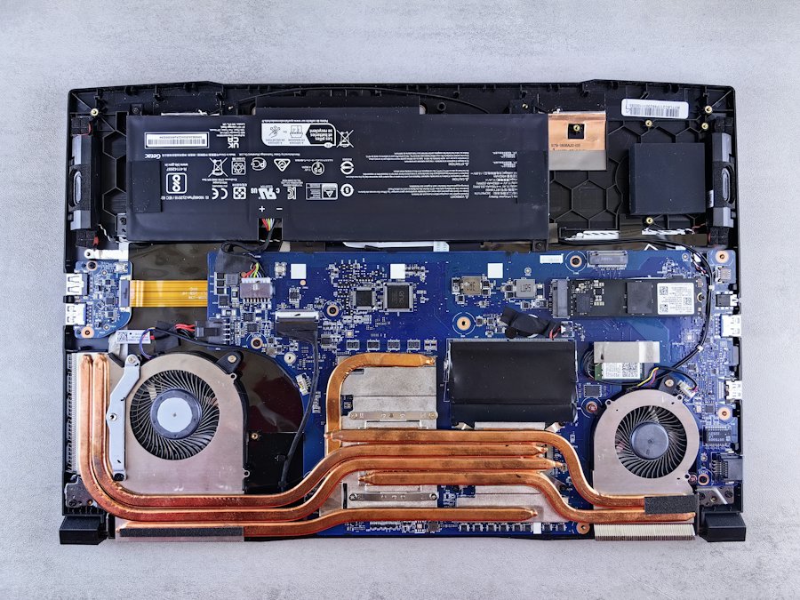 Opened laptop showing the battery, fans and motherboard